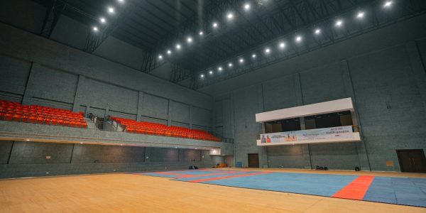 Empty indoor sports arena with seating and court markings.